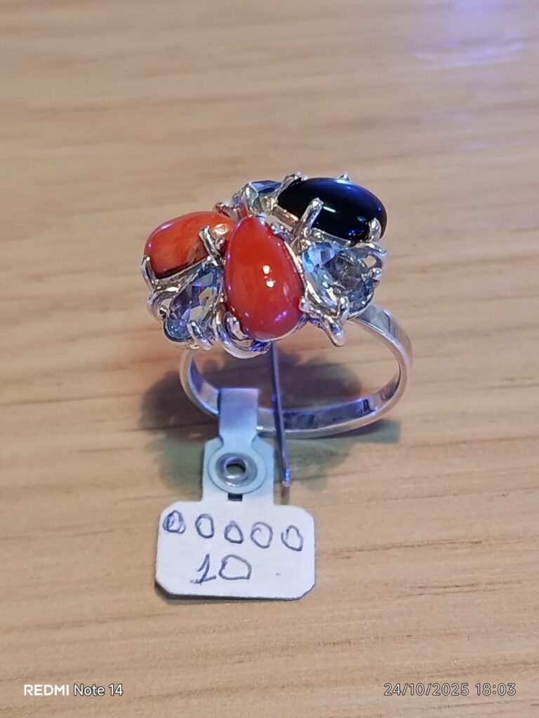 Anel de prata com topazio azul, coral e ônix.